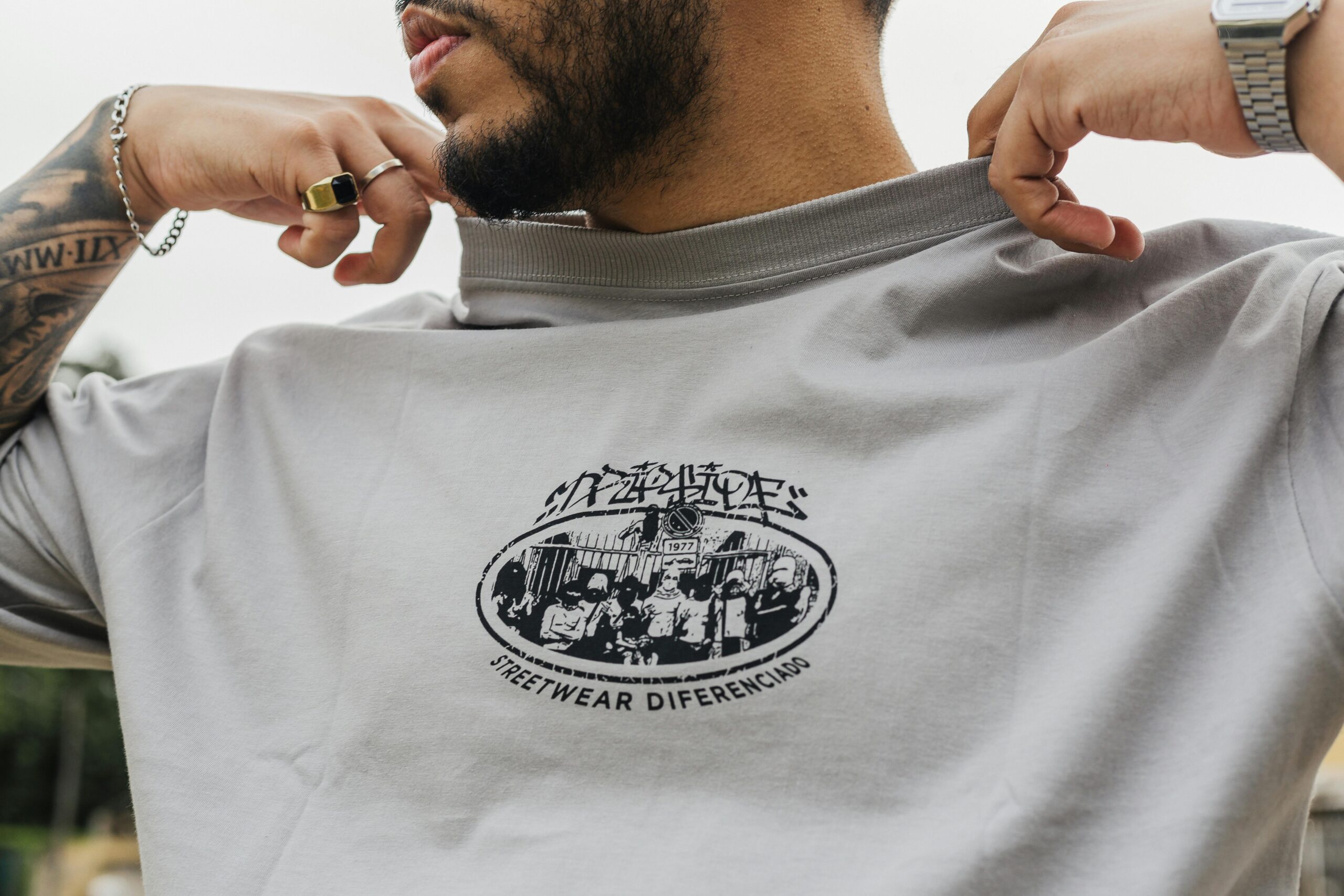 Home A fashionable man displays a graphic streetwear t-shirt outdoors in São Paulo, Brazil.