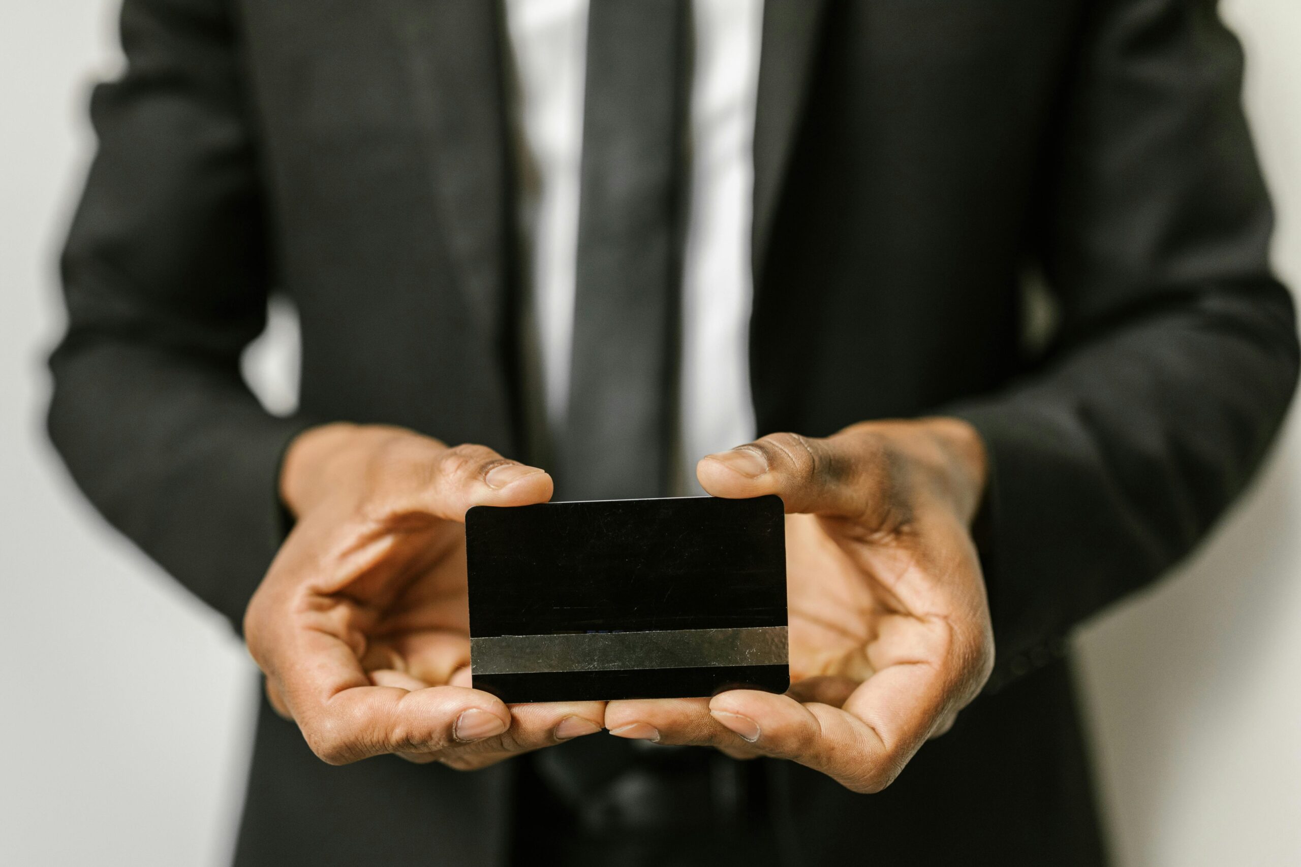 Home Close-up of a businessman holding a blank credit card with both hands, emphasizing finance.